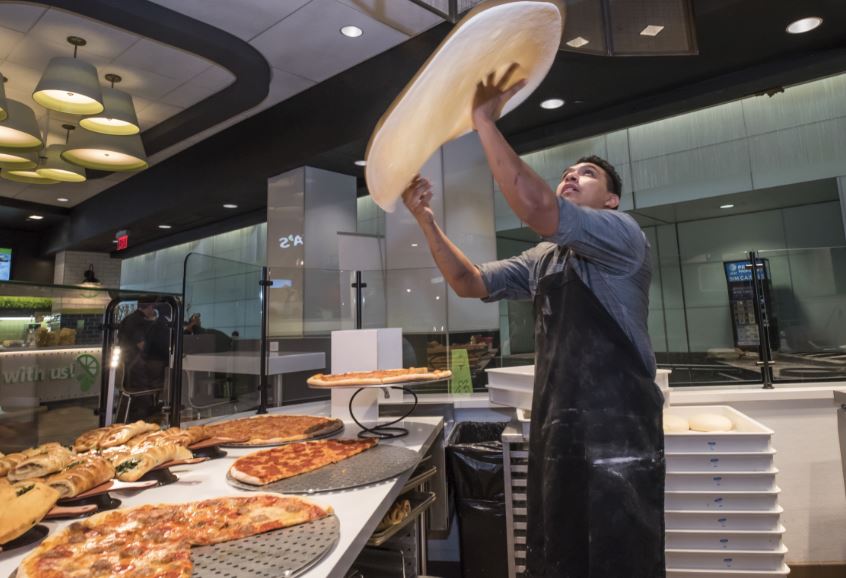a cook holding a large dough