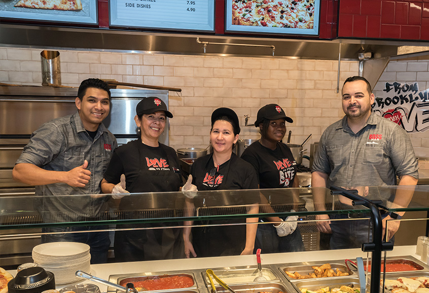 Happy staff standing in front of a counter